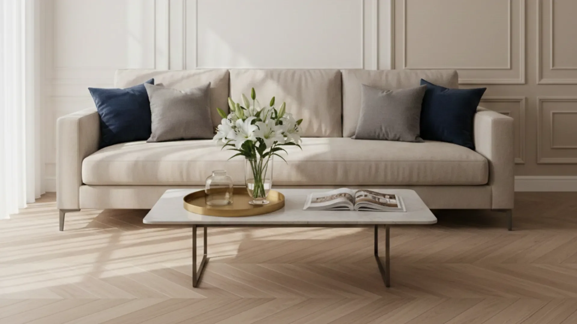 Jasny salon po home stagingu: beżowa sofa, granatowe poduszki i lilie na stoliku